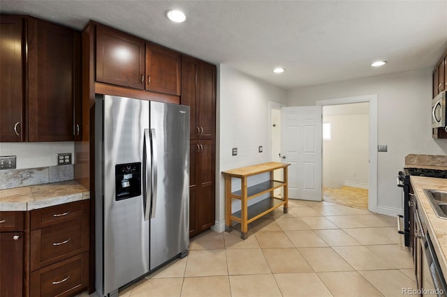 702 E Platte Ave, Colorado Springs, CO 80903 - kitchen with stainless steel appliances, light countertops, recessed lighting, baseboards, and light tile patterned floors