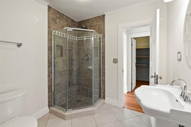 702 E Platte Ave, Colorado Springs, CO 80903 - full bathroom featuring tile patterned flooring, a stall shower, a sink, toilet, and crown molding