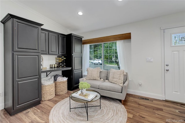 living room featuring crown molding and light wood-type flooring