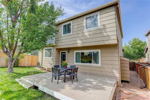 rear view of property with a wooden deck and a yard