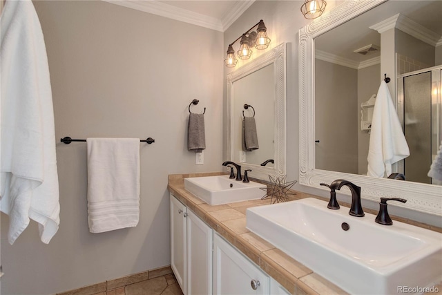 bathroom featuring a shower with door, vanity, crown molding, and tile patterned flooring