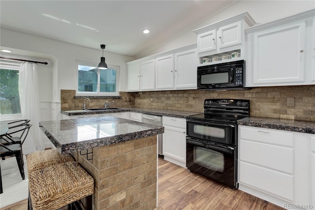 kitchen with backsplash, black appliances, vaulted ceiling, and decorative light fixtures