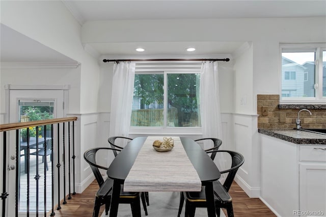 dining room with sink, dark wood-type flooring, and crown molding