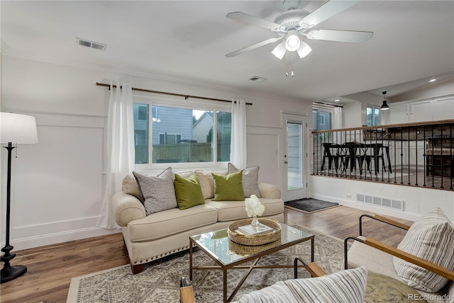 living room featuring crown molding, hardwood / wood-style flooring, and ceiling fan