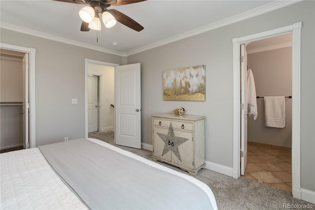 bedroom with a closet, a walk in closet, crown molding, light colored carpet, and ceiling fan