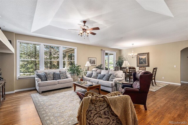 11422 W Cooper Ave, Littleton, CO 80127 - living area featuring ceiling fan, baseboards, wood finished floors, a chandelier, and arched walkways