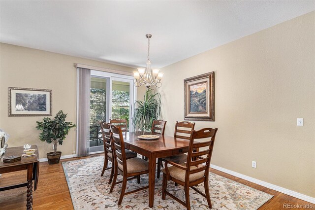 11422 W Cooper Ave, Littleton, CO 80127 - dining space featuring a chandelier, wood finished floors, and baseboards