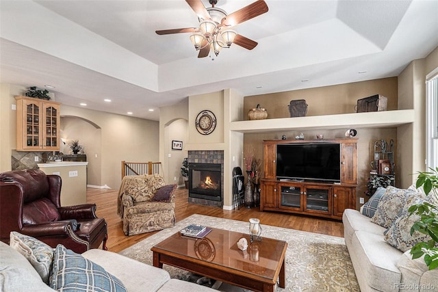 11422 W Cooper Ave, Littleton, CO 80127 - living room featuring a raised ceiling, arched walkways, light wood-type flooring, ceiling fan, and recessed lighting