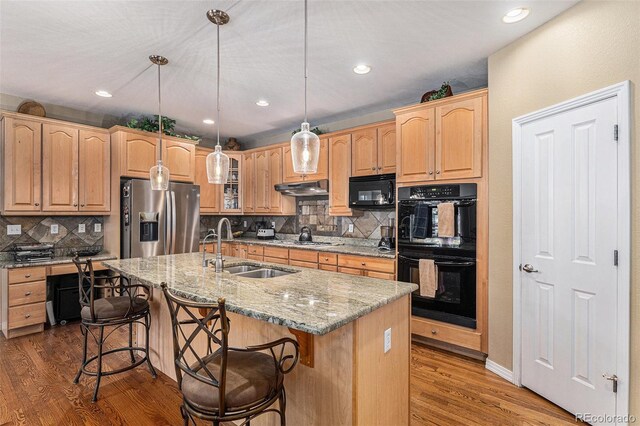 11422 W Cooper Ave, Littleton, CO 80127 - kitchen featuring black appliances, a sink, under cabinet range hood, light stone countertops, and wood finished floors