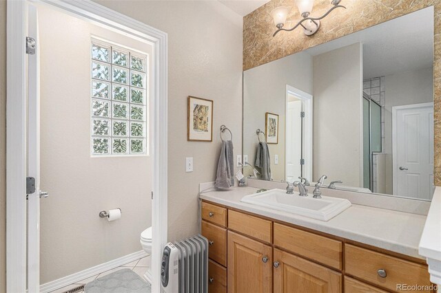 11422 W Cooper Ave, Littleton, CO 80127 - bathroom with radiator, toilet, vanity, baseboards, and tile patterned floors