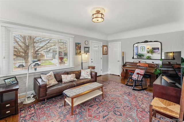 living room with a textured wall, baseboards, and wood finished floors