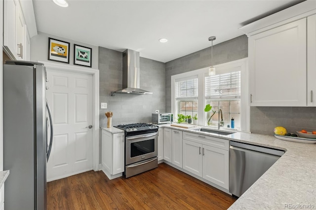 kitchen with wall chimney exhaust hood, tasteful backsplash, dark wood-style flooring, a sink, and stainless steel appliances