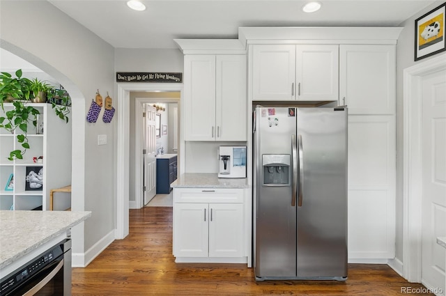 kitchen with baseboards, dark wood-style floors, white cabinets, appliances with stainless steel finishes, and arched walkways