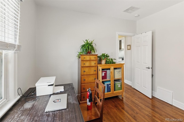 office area featuring visible vents, baseboards, and wood finished floors