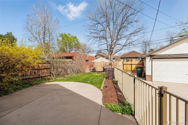 view of yard with an outdoor structure, a fenced backyard, a garage, and a patio area