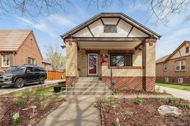 bungalow-style home featuring a porch and brick siding