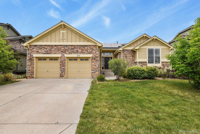 297 N Coolidge Way, Aurora, CO 80018 - craftsman inspired home with board and batten siding, stone siding, driveway, a front lawn, and roof mounted solar panels