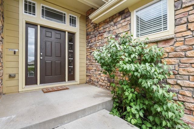 297 N Coolidge Way, Aurora, CO 80018 - entrance to property featuring stone siding and a porch