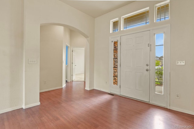 297 N Coolidge Way, Aurora, CO 80018 - entryway featuring arched walkways, wood finished floors, and baseboards