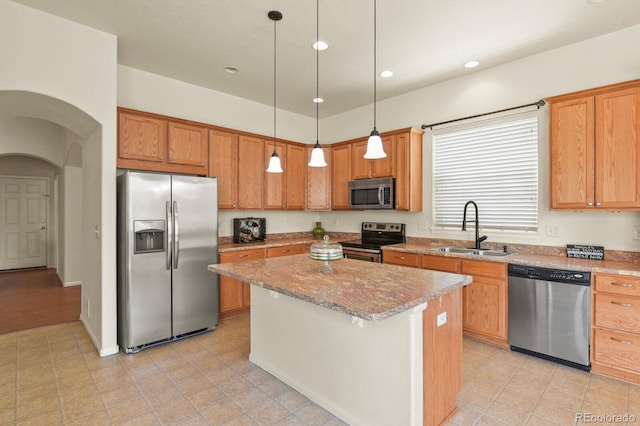 297 N Coolidge Way, Aurora, CO 80018 - kitchen featuring stainless steel appliances, a sink, a center island, light stone counters, and hanging light fixtures
