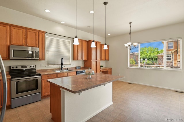 297 N Coolidge Way, Aurora, CO 80018 - kitchen with stainless steel appliances, a sink, brown cabinetry, pendant lighting, and recessed lighting