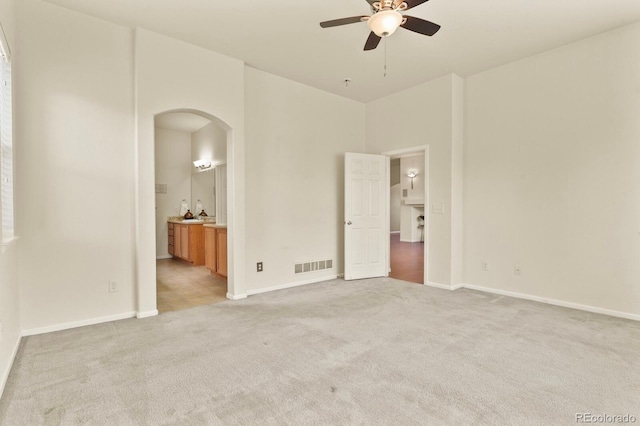 297 N Coolidge Way, Aurora, CO 80018 - unfurnished bedroom featuring arched walkways, light carpet, ensuite bathroom, and baseboards