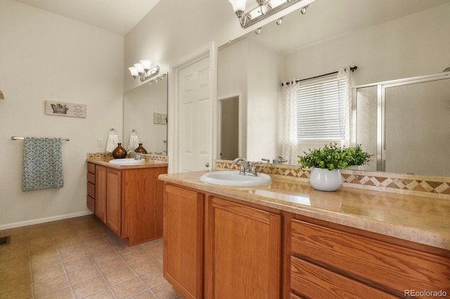 297 N Coolidge Way, Aurora, CO 80018 - full bath with a shower stall, two vanities, tile patterned flooring, and baseboards