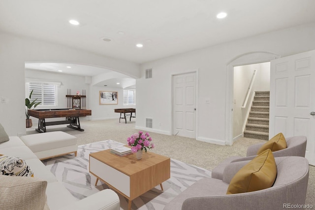 297 N Coolidge Way, Aurora, CO 80018 - living area featuring arched walkways, recessed lighting, light carpet, stairway, and baseboards
