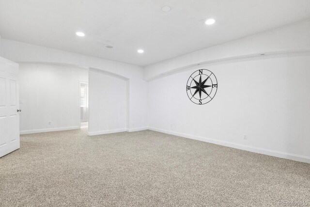 297 N Coolidge Way, Aurora, CO 80018 - spare room featuring light colored carpet, recessed lighting, arched walkways, and baseboards
