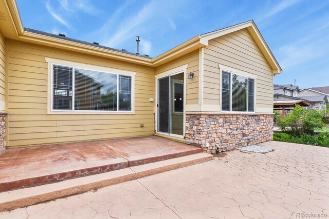 297 N Coolidge Way, Aurora, CO 80018 - entrance to property with a patio and stone siding