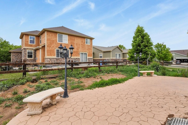 297 N Coolidge Way, Aurora, CO 80018 - back of house featuring stone siding and a patio area