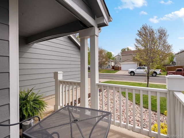 balcony featuring outdoor dining space, a residential view, and a porch