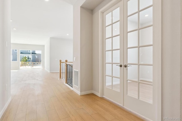 hallway with french doors and light wood-type flooring