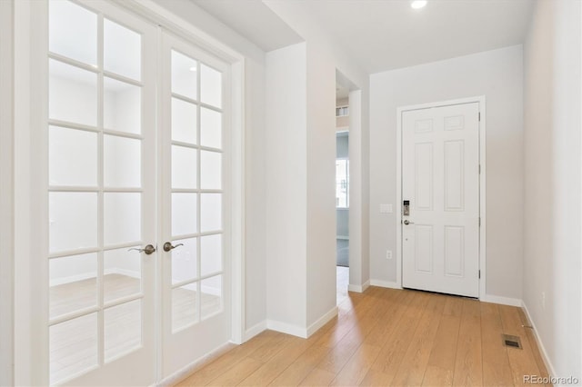 foyer entrance with light wood-type flooring and french doors