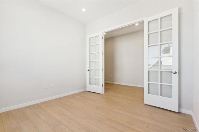 spare room with light wood-type flooring and french doors