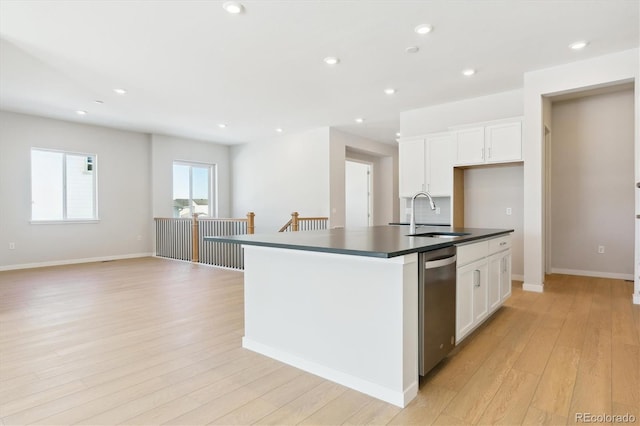 kitchen with sink, light hardwood / wood-style floors, an island with sink, white cabinets, and stainless steel dishwasher