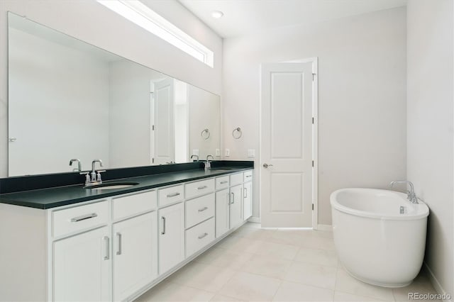 bathroom featuring vanity, tile patterned flooring, and a washtub