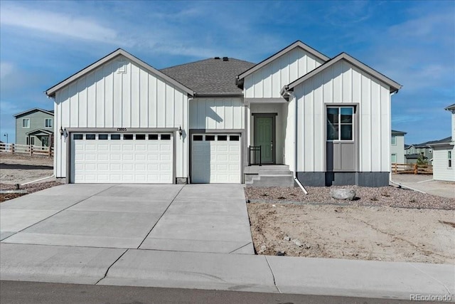 modern farmhouse with board and batten siding, driveway, and a garage