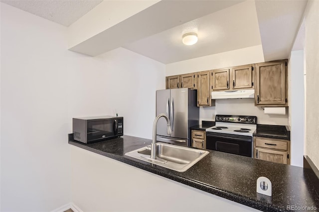 kitchen with white electric range oven, stainless steel fridge, sink, and kitchen peninsula