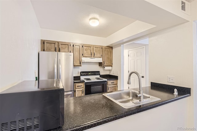 kitchen featuring a raised ceiling, sink, white electric range oven, and stainless steel fridge