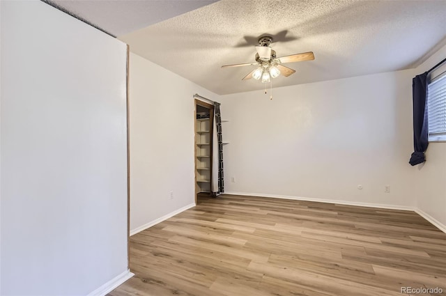 unfurnished room with light wood-type flooring, a textured ceiling, and ceiling fan