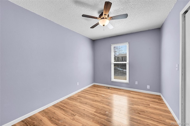 unfurnished room featuring baseboards, light wood-style floors, ceiling fan, and a textured ceiling