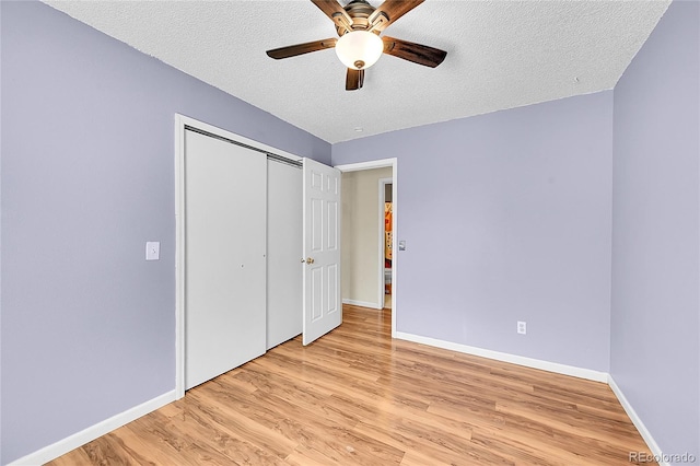 unfurnished bedroom with a ceiling fan, a textured ceiling, a closet, light wood-style floors, and baseboards