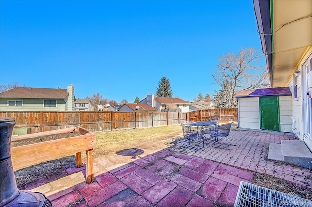 view of patio featuring outdoor dining space, a garden, and a fenced backyard