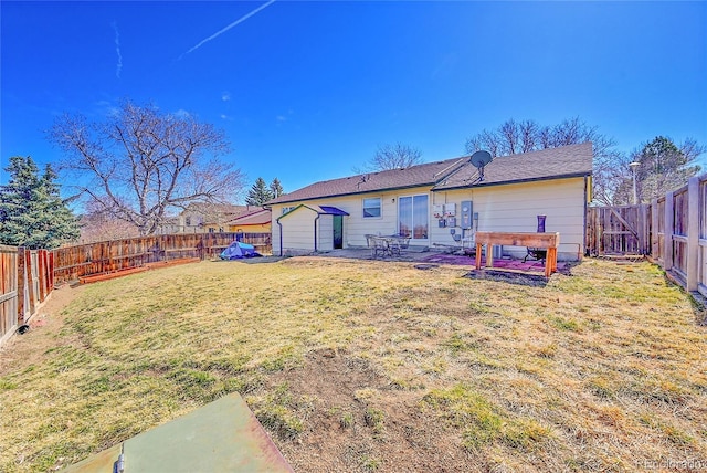 rear view of house featuring a yard and a fenced backyard