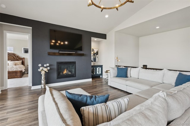 living area featuring recessed lighting, a glass covered fireplace, wood finished floors, and a notable chandelier
