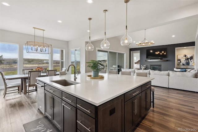 kitchen featuring light countertops, dark brown cabinets, a chandelier, and a sink