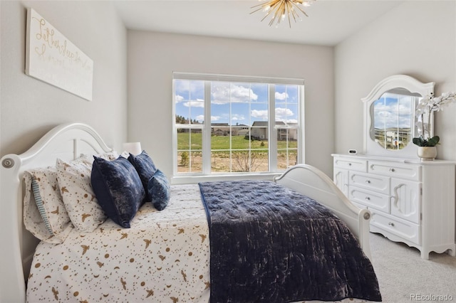 bedroom featuring carpet flooring and a notable chandelier