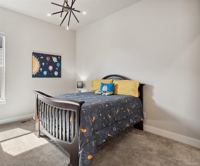 bedroom featuring baseboards, carpet flooring, and an inviting chandelier