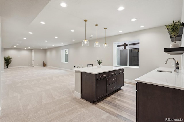 kitchen featuring dark brown cabinetry, light carpet, baseboards, recessed lighting, and a sink